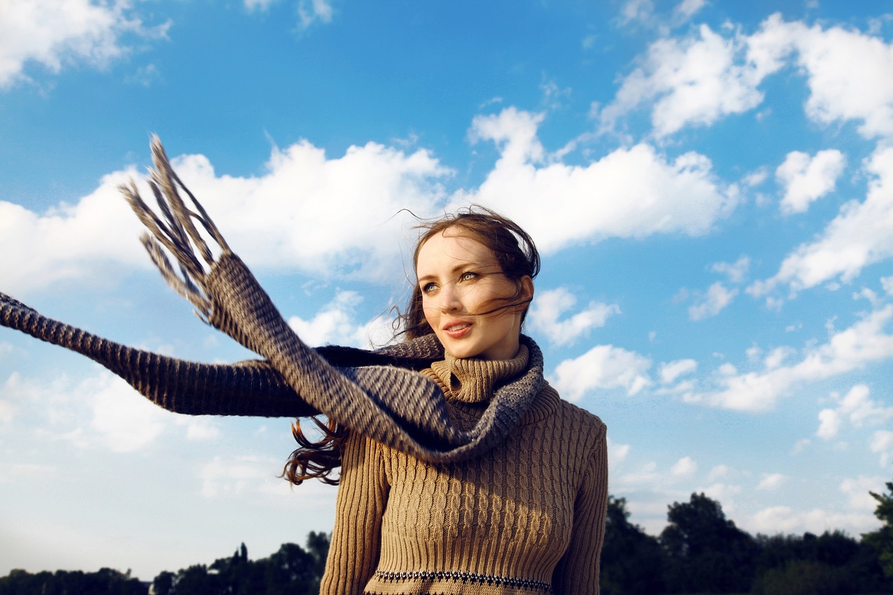 Woman with scarf around neck blowing in wind