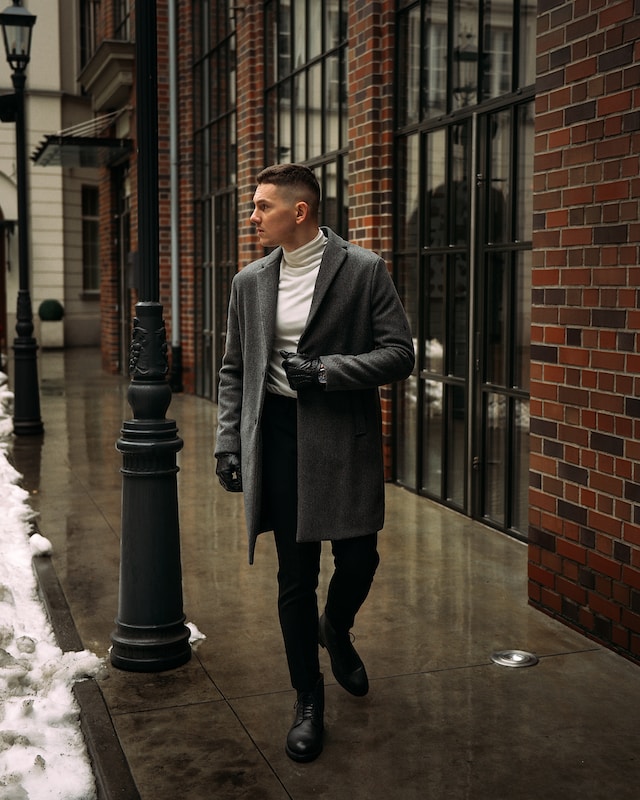 Man wearing long wool coat walking down sidewalk